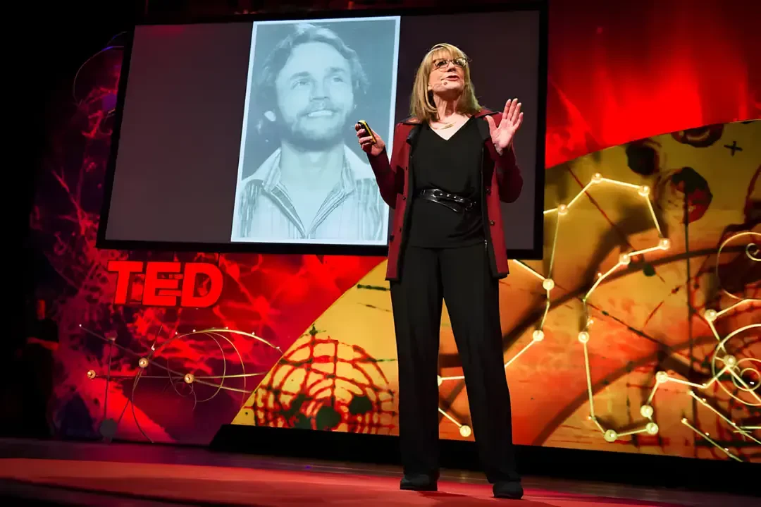سخنرانی زن در تد (TED) در مقابل تصویری سیاه و سفید از یک مرد